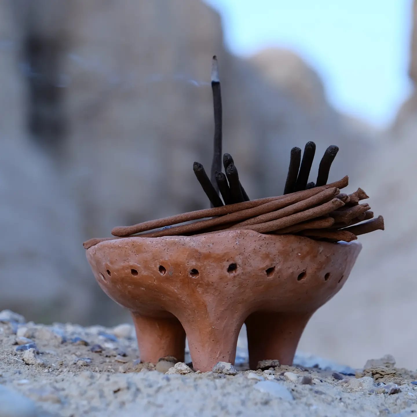 Terracotta incense burner with Handmade incense sticks on a natural stone surface
