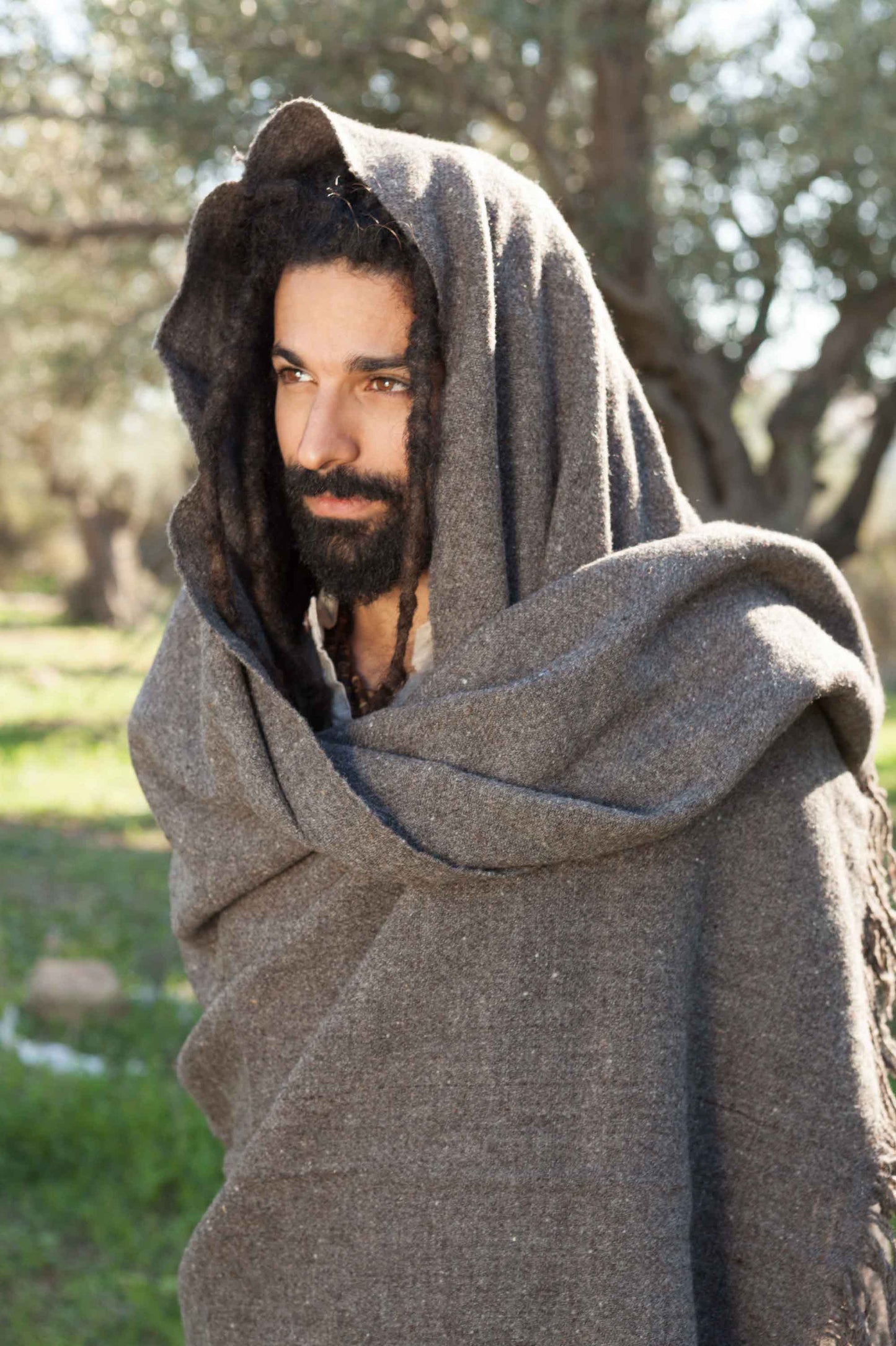 Gray handwoven natural wool shawl worn as a hooded wrap outdoors