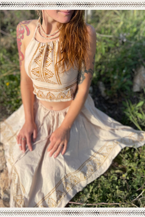 Woman wearing natural clothing featuring tribal-inspired camel blockprint top and skirt from Ancient Butterfly Outfit Skirt + Top Camel Blockprint set sitting outdoors on grass