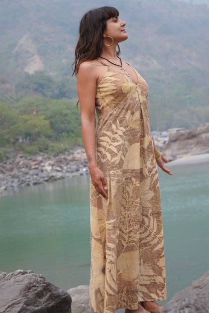 Side view of a beautiful eco-printed maxi dress featuring unique botanical leaf and bark patterns, worn by a woman outdoors.