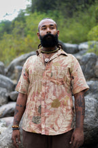 Man outdoors wearing a unique natural leaf print short sleeve shirt. Botanical dye slow fashion button down for men.