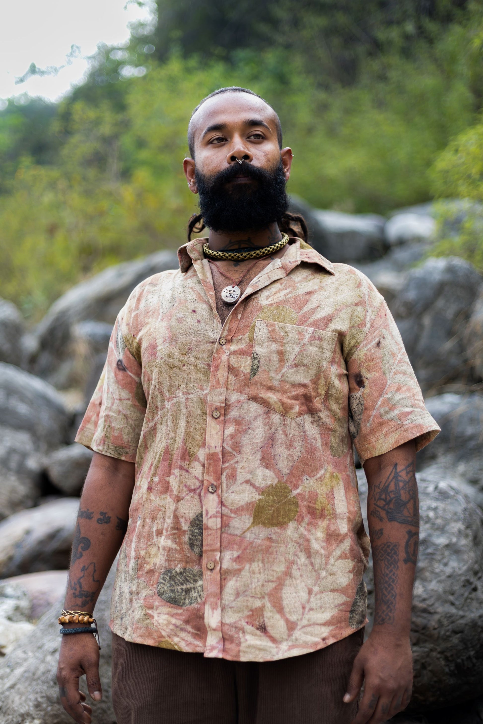 Man outdoors wearing a unique natural leaf print short sleeve shirt. Botanical dye slow fashion button down for men.