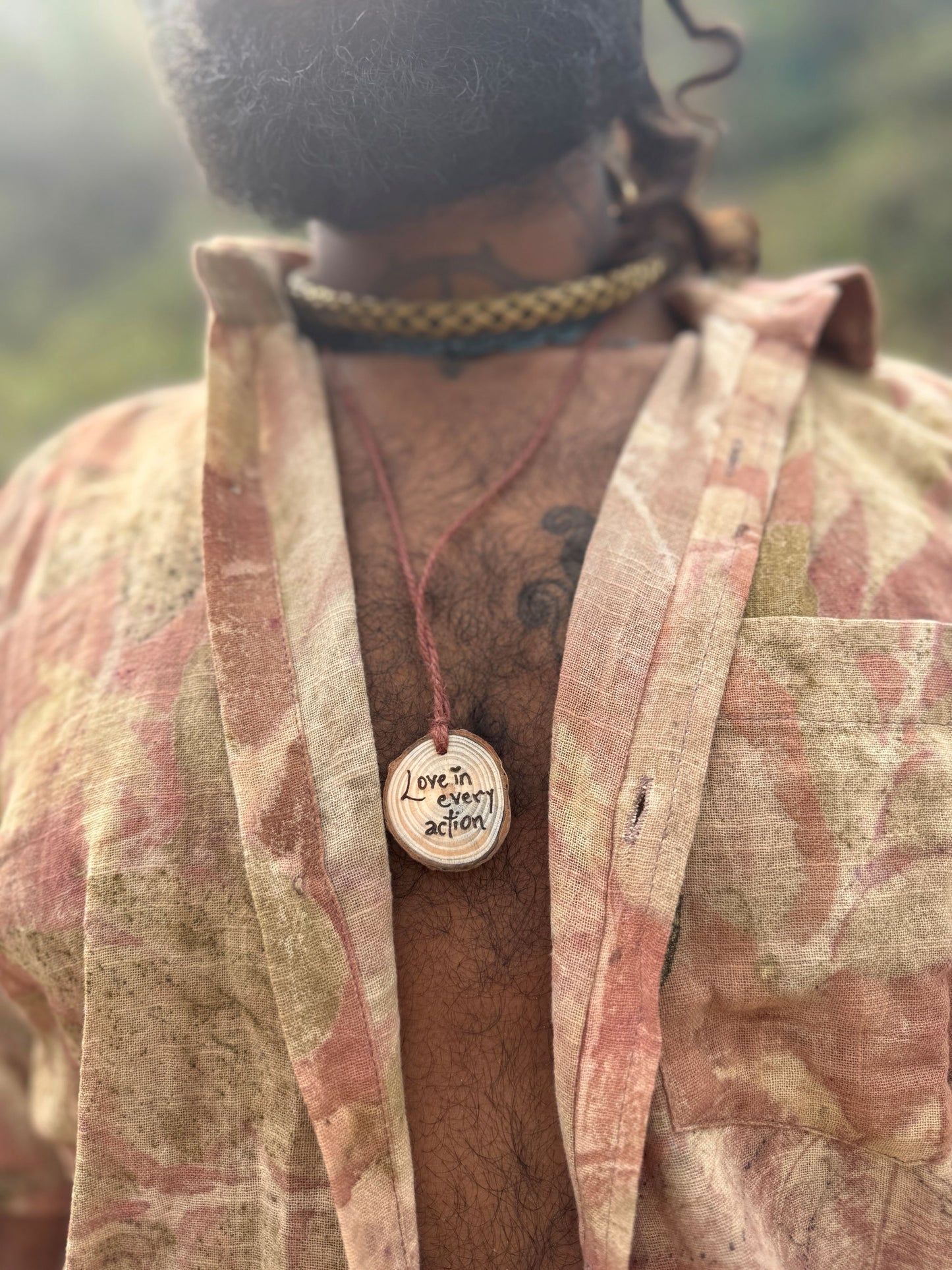 Close up of an earthy botanical print short sleeve shirt made with natural plant dye. Eco printed boho menswear featuring real leaf patterns.