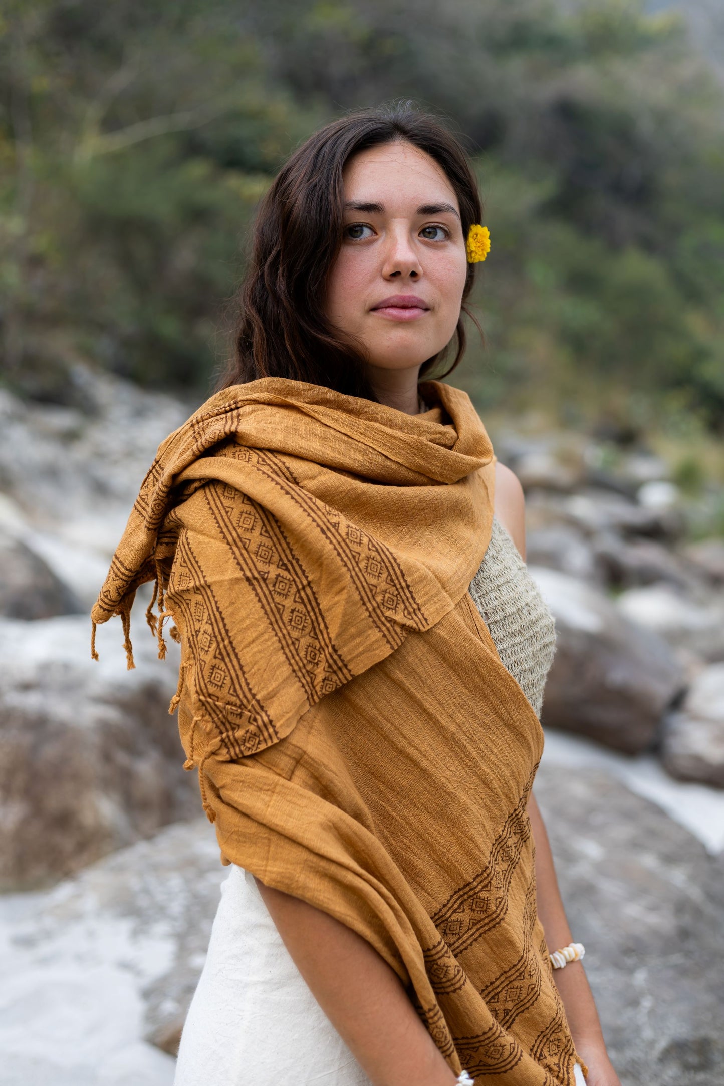 Brown handwoven cotton scarf worn as a shawl over a boho outfit. Eco-friendly tribal wrap with wooden block prints