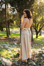 Back view of a model wearing the Earth Wrap Skirt, a long natural cotton wrap skirt, photographed outdoors in sunlight.