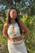 Side portrait of a an Earthy Woman wearing a raw silk halter top with earthy tribal block print, shot outdoors in warm golden light.