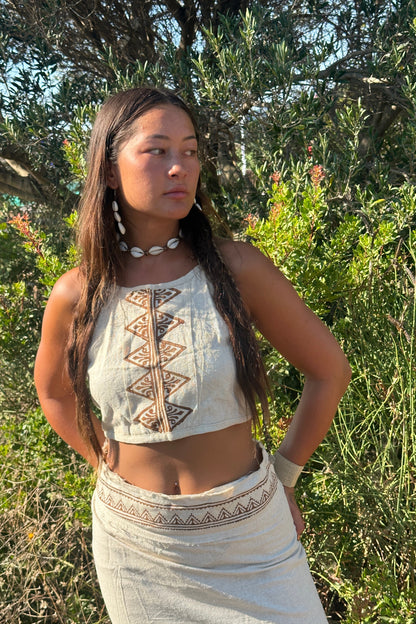 Side portrait of a an Earthy Woman wearing a raw silk halter top with earthy tribal block print, shot outdoors in warm golden light.