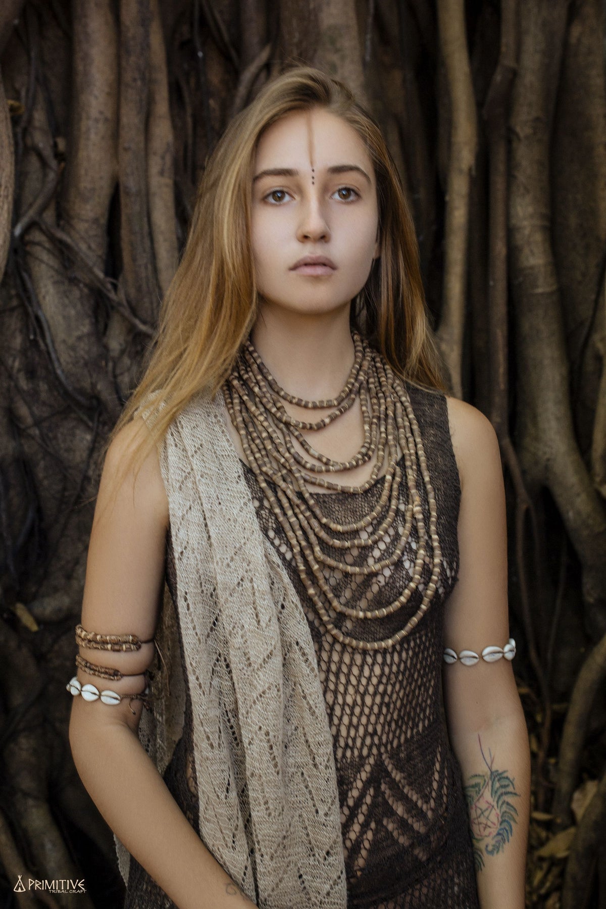 Close-up of a woman wearing the multi-strand Tulsi wood bead necklace showing the natural brown tones and varying bead
sizes across all 10 strands