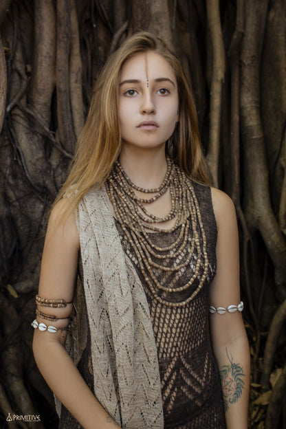 Close-up of a woman wearing the multi-strand Tulsi wood bead necklace showing the natural brown tones and varying bead
sizes across all 10 strands