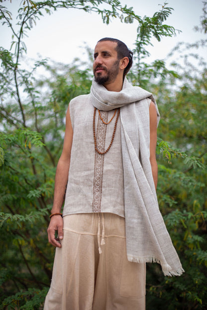 Man wearing a Grey Wool Shawl  outdoors with greenery in the background