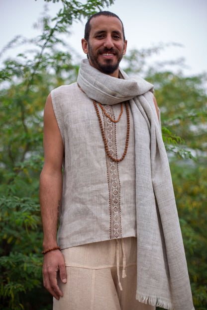 Man wearing Thin Handwoven Grey Wool Shawl necklace, standing outdoors with greenery in the background