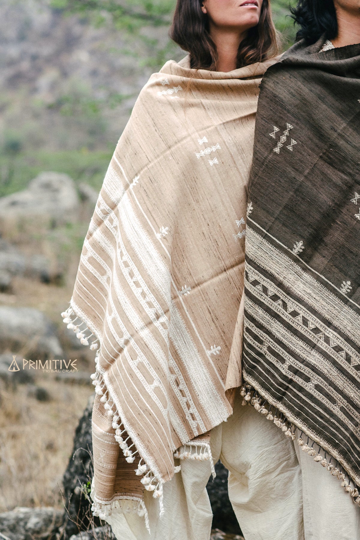 Texture shot of a beige tribal meditation shawl showing rows of white geometric weaving and handmade tassels. Authentic Gujarati craftsmanship.