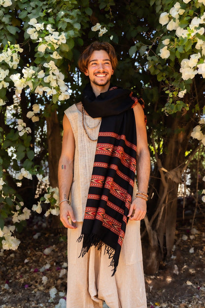 Man standing outdoors wearing a black Kullu handloom shawl, 100% wool with tribal pattern