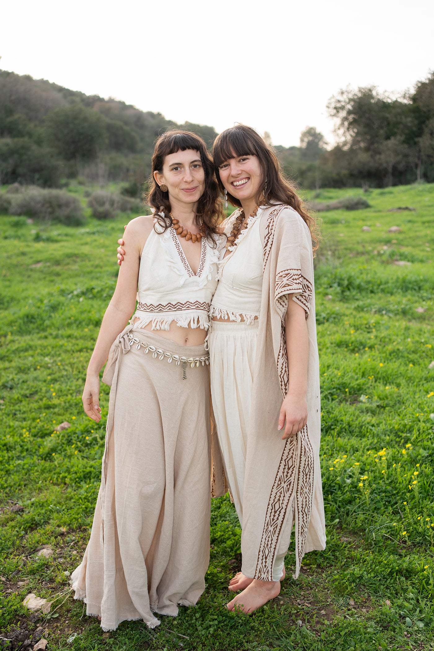 Two Women wearing a lightweight natural cotton kimono with brown block print borders, styled as an earthy boho layering piece outdoors