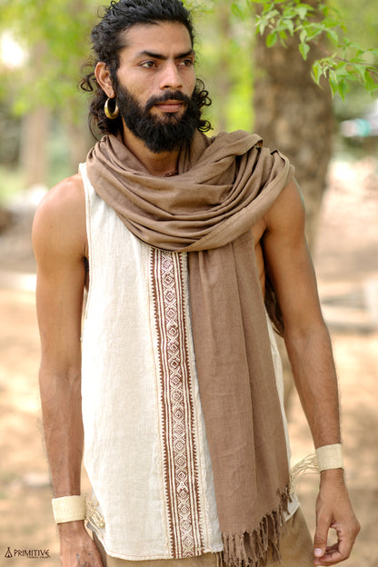 Front view of an earthy man wearing a natural handwoven raw silk tank top with a central tribal block print, styled with a brown scarf.