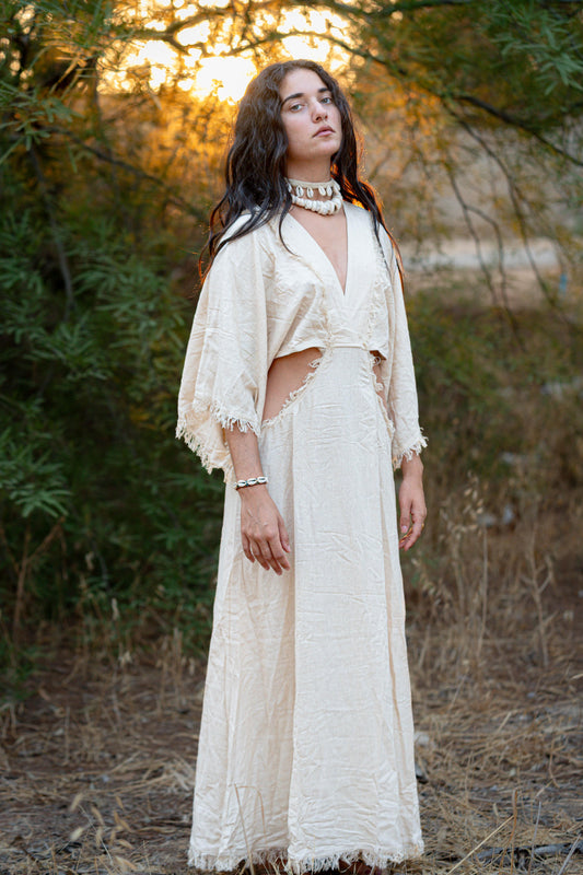 Model wearing a white maxi goddess dress made from handwoven raw silk, photographed outdoors.