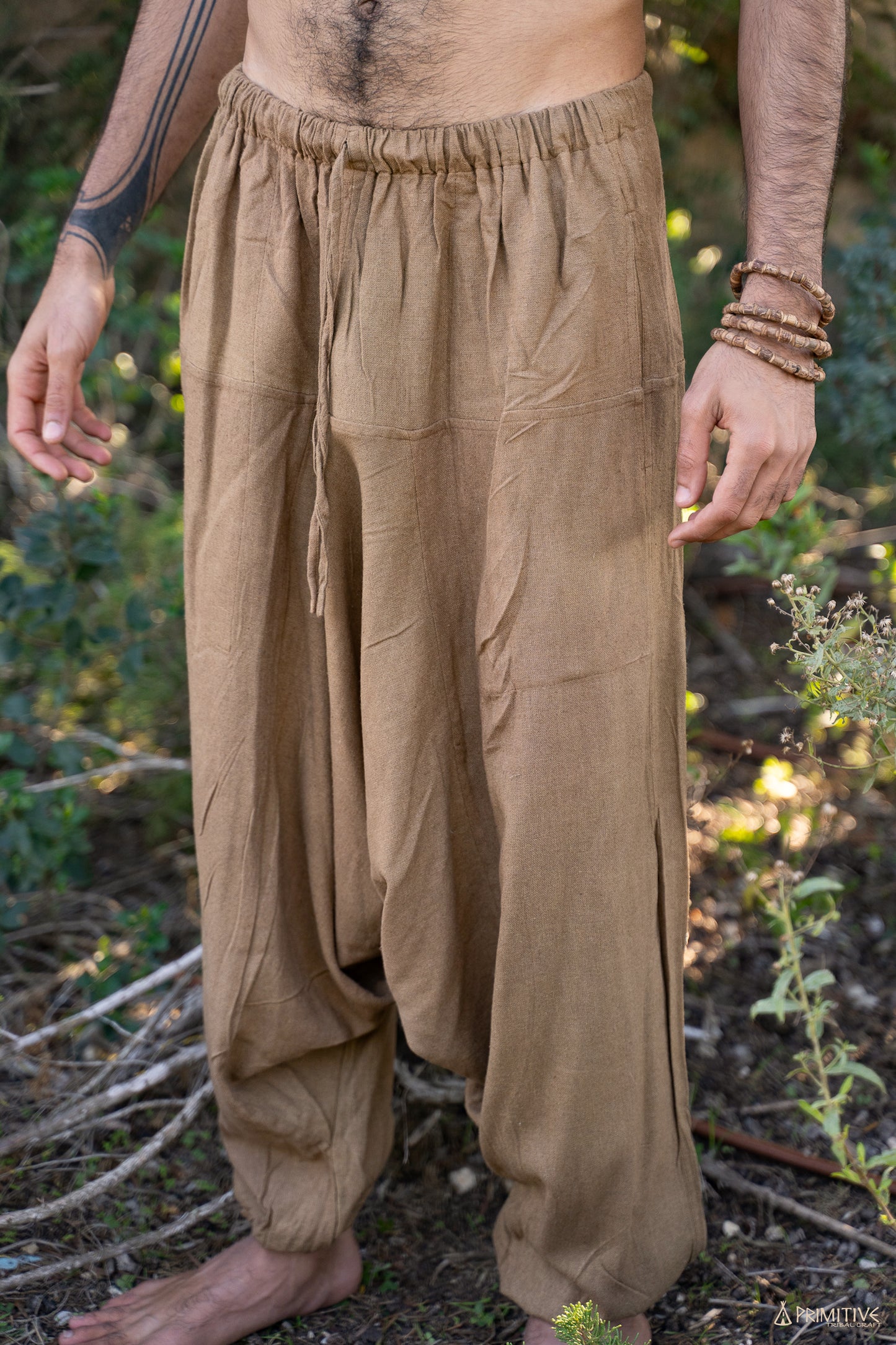 Close-up of handwoven raw silk afghani pants in earthy brown, showing elastic waistband, roomy drape and relaxed boho fit.