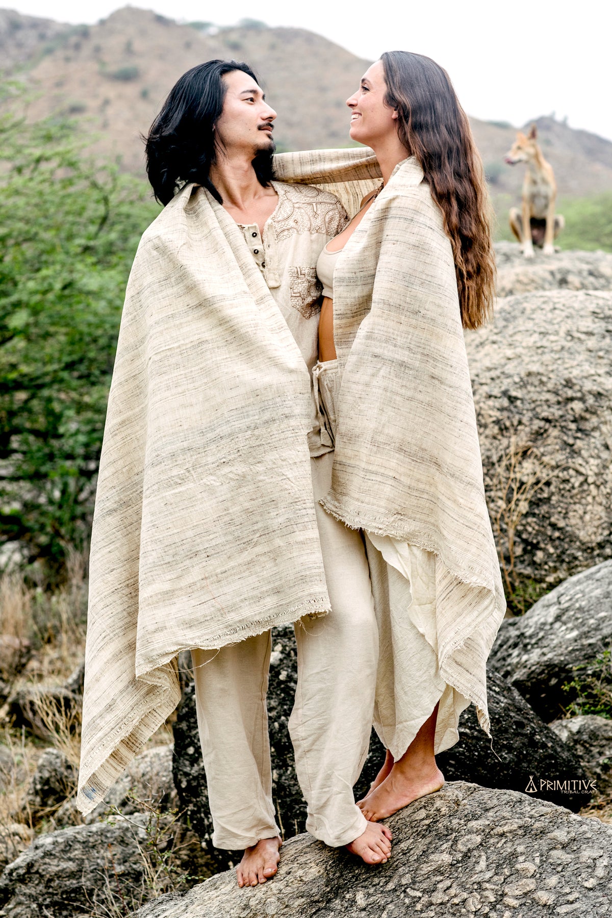 a couple standing covered in a large wild silk shawl