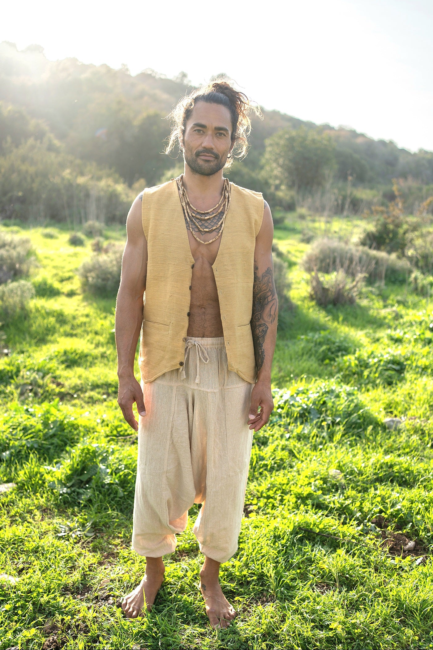 Full body front view of camel khadi cotton vest with harem pants, minimalist earthy unisex outfit in a sunlit meadow.
