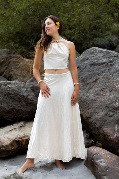 Woman standing on river rocks wearing a white handloom khadi cotton maxi wrap skirt 