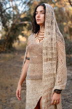Model wearing a lightweight natural nettle-fiber shawl with an open-weave texture, draped over her head outdoors