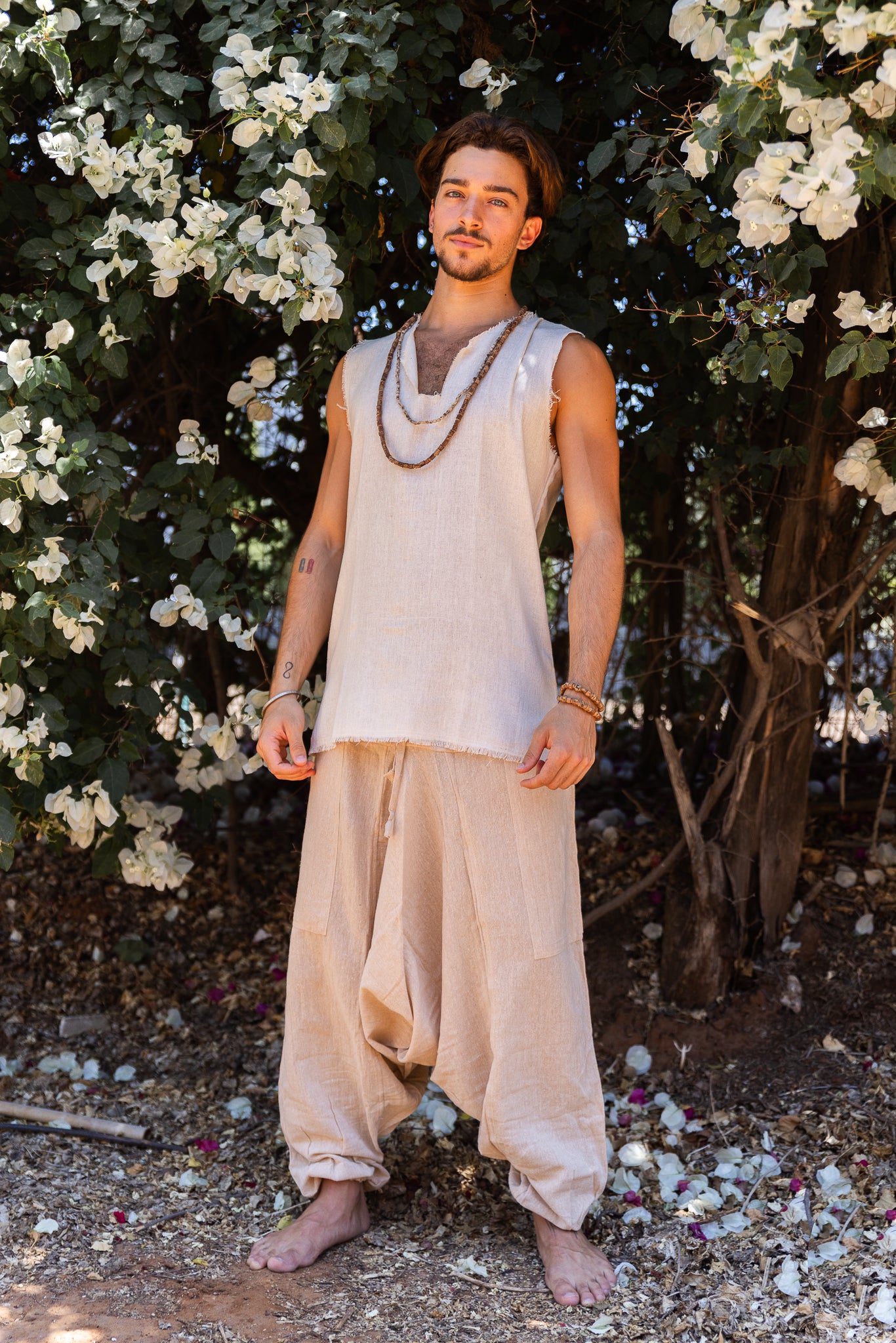 men wearing beige natural cotton harem pants with drop crotch and drawstring waist, full length front view