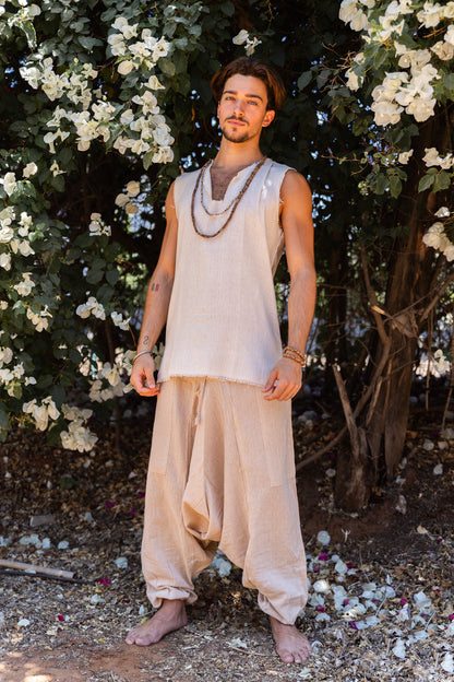 men wearing beige natural cotton harem pants with drop crotch and drawstring waist, full length front view
