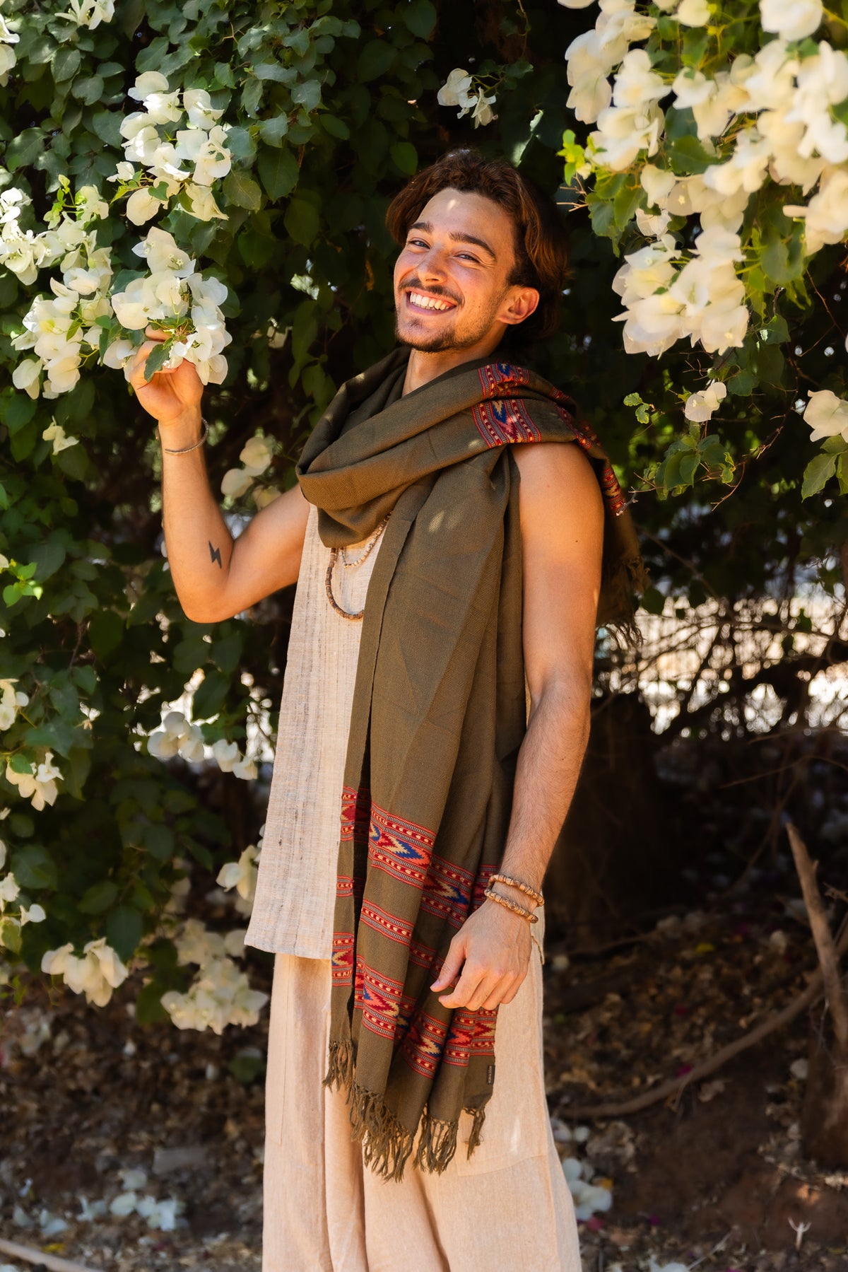 Man wearing an olive Kullu handloom wool shawl with red woven stripes, traditional Himalayan textile