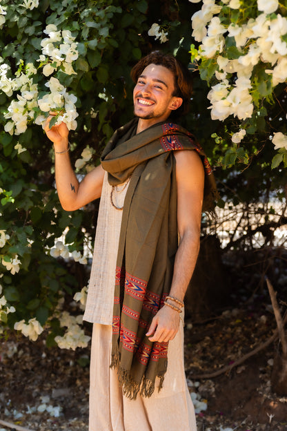 Man wearing an olive Kullu handloom wool shawl with red woven stripes, traditional Himalayan textile