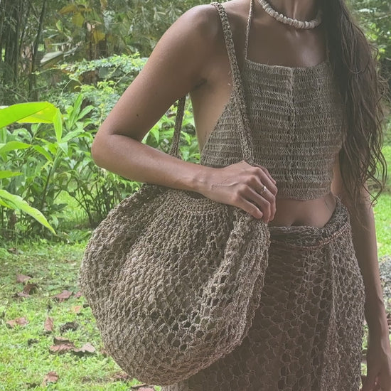 Oversized handwoven wild hemp market bag with an open-weave net texture, photographed outdoors.