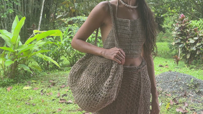 Oversized handwoven wild hemp market bag with an open-weave net texture, photographed outdoors.