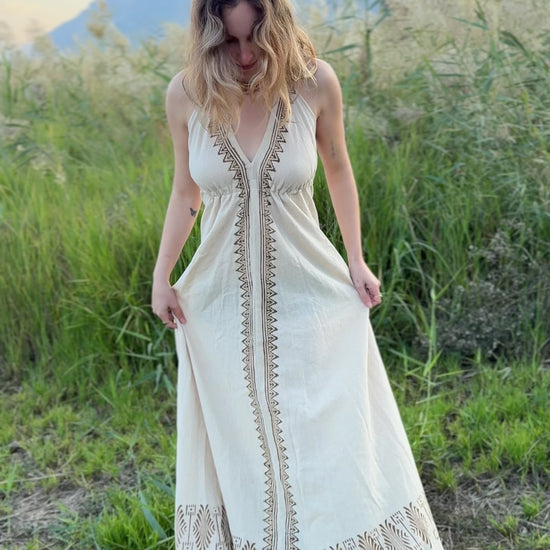 Video showing the fit and flow of the Naya long butterfly dress - a natural cotton maxi dress with block print details - filmed outdoors.