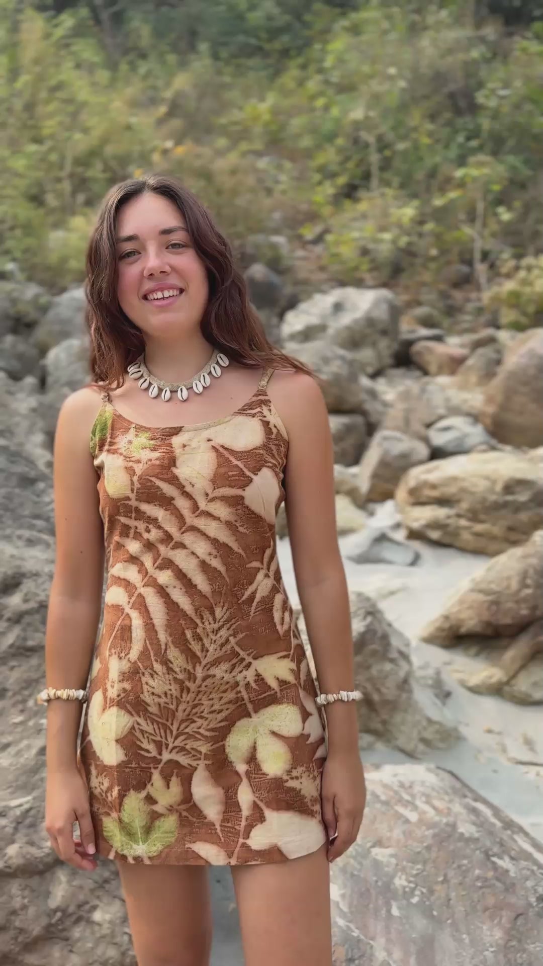 Woman wearing earthy short botanical dye dress with leaf prints. Eco-friendly slow fashion