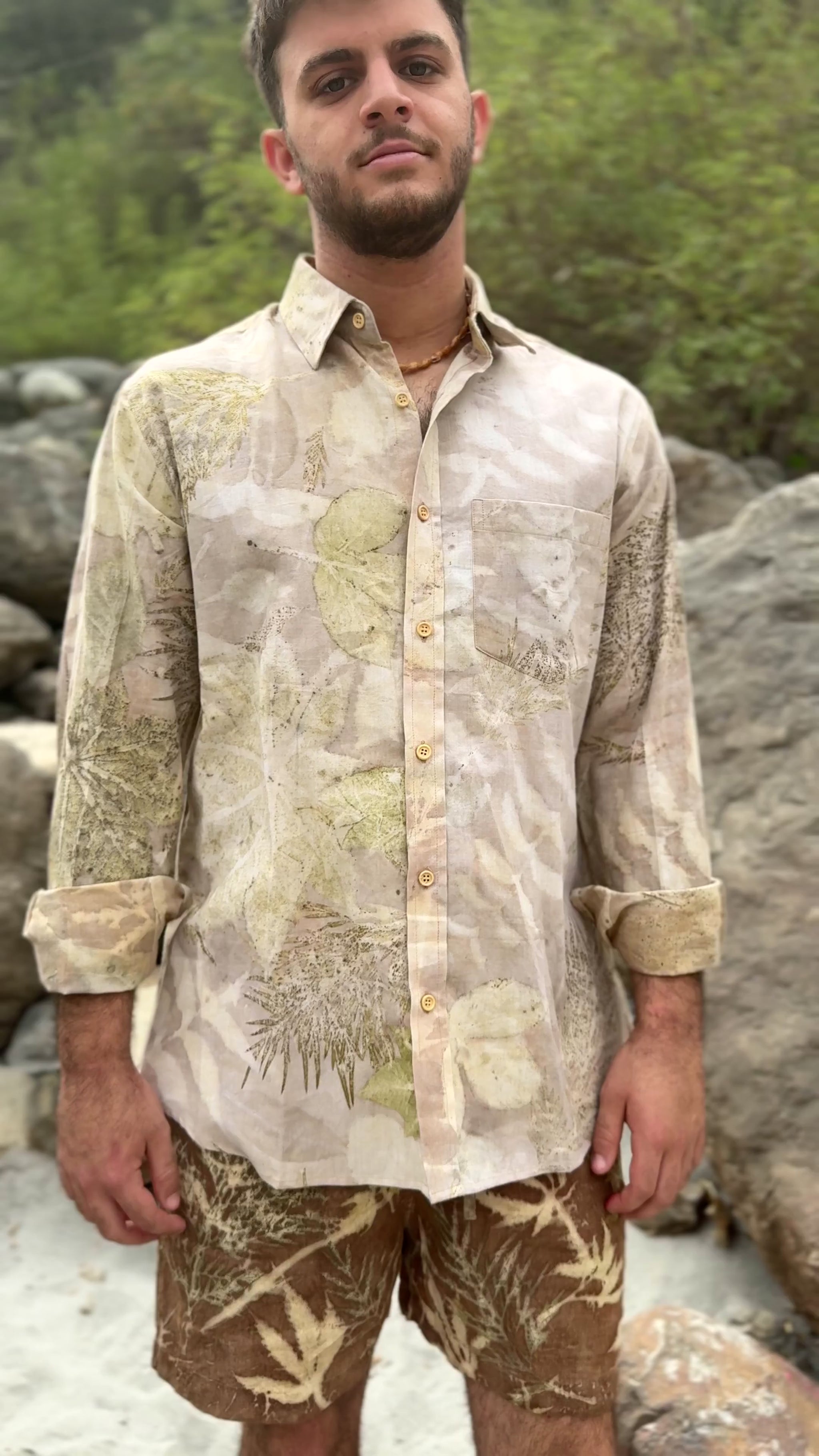 Close up video showing a light earthy botanical print long-sleeve button-down shirt with rolled sleeves. Men's eco-friendly slow fashion