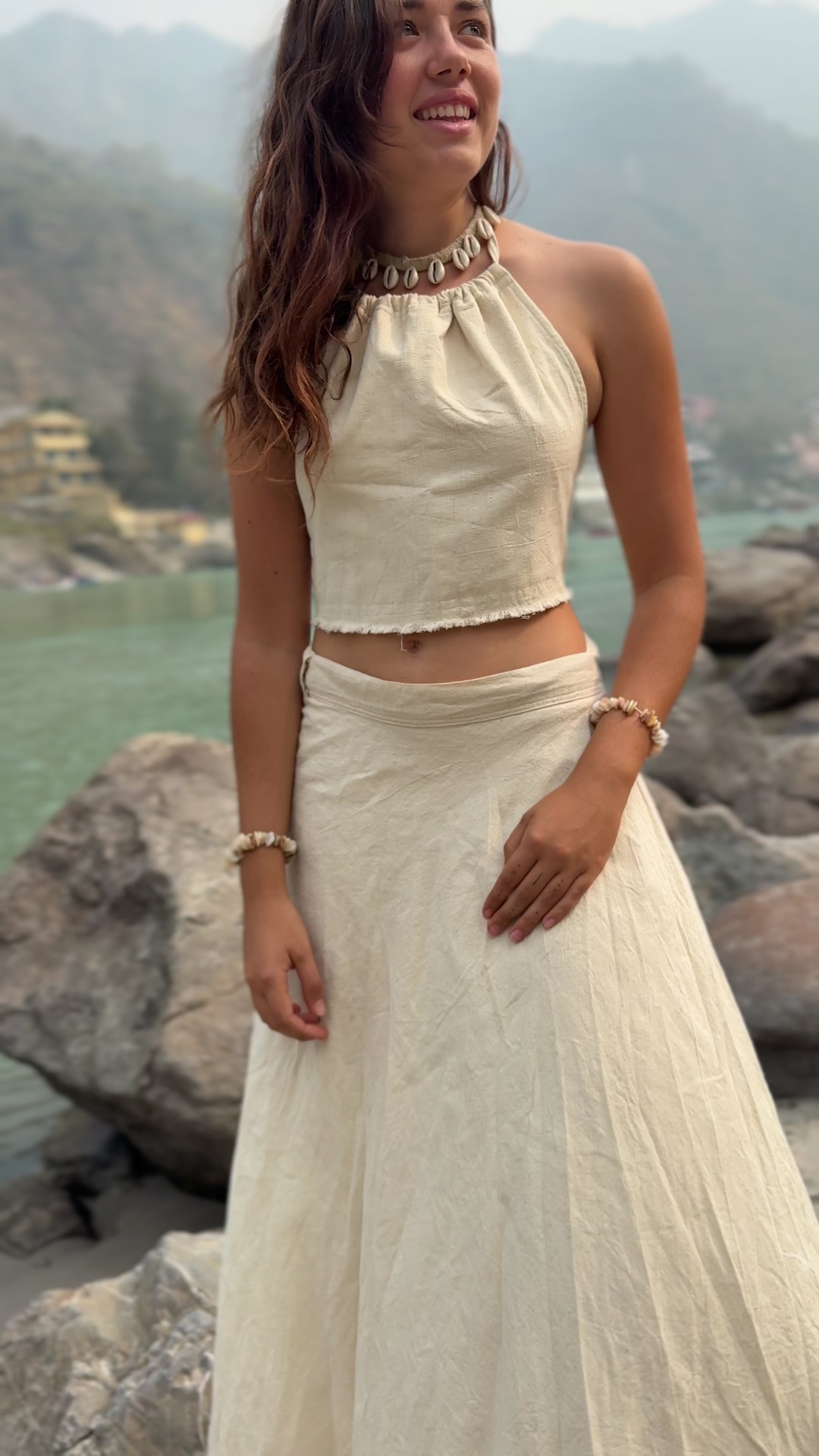 Woman outdoors in nature wearing a flowy white khadi cotton wrap skirt and crop top.