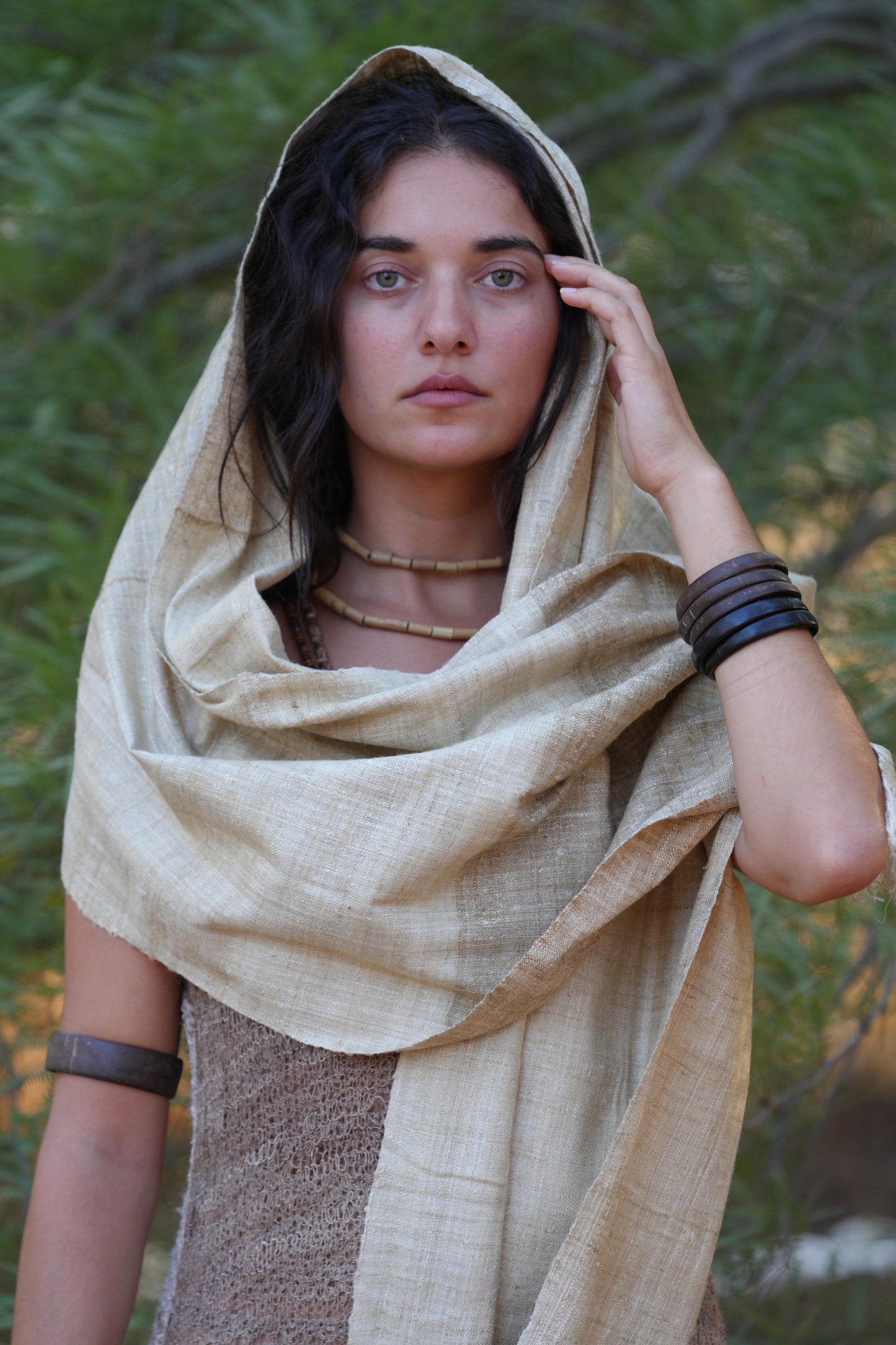 Close-up of a Woman wrapped in a handwoven mulberry raw silk shawl, showing the textured fabric and natural beige tone.