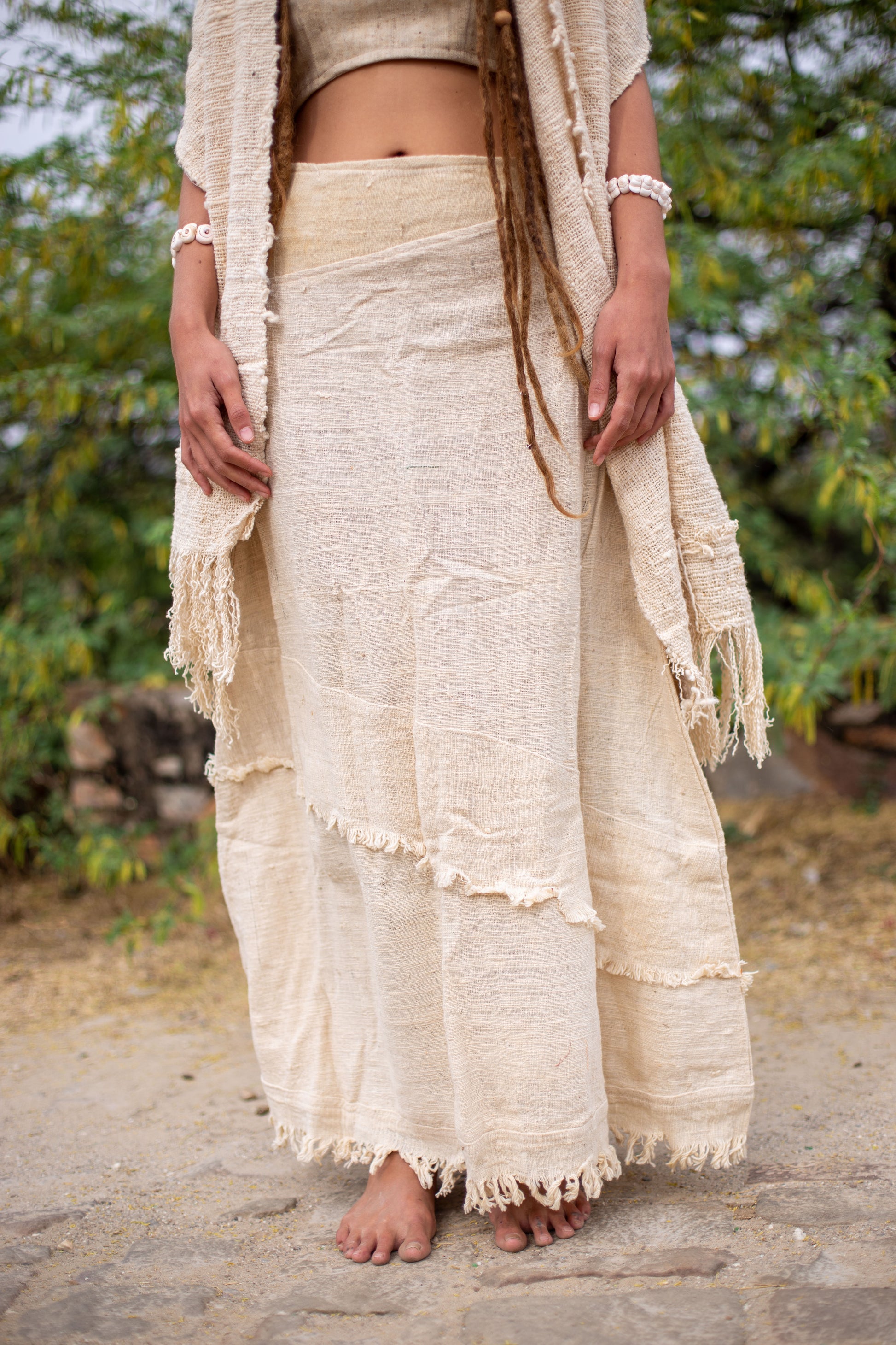 Close-up of thick raw khadi cotton maxi skirt showing handwoven texture, natural undyed fabric, and frayed hem detail.