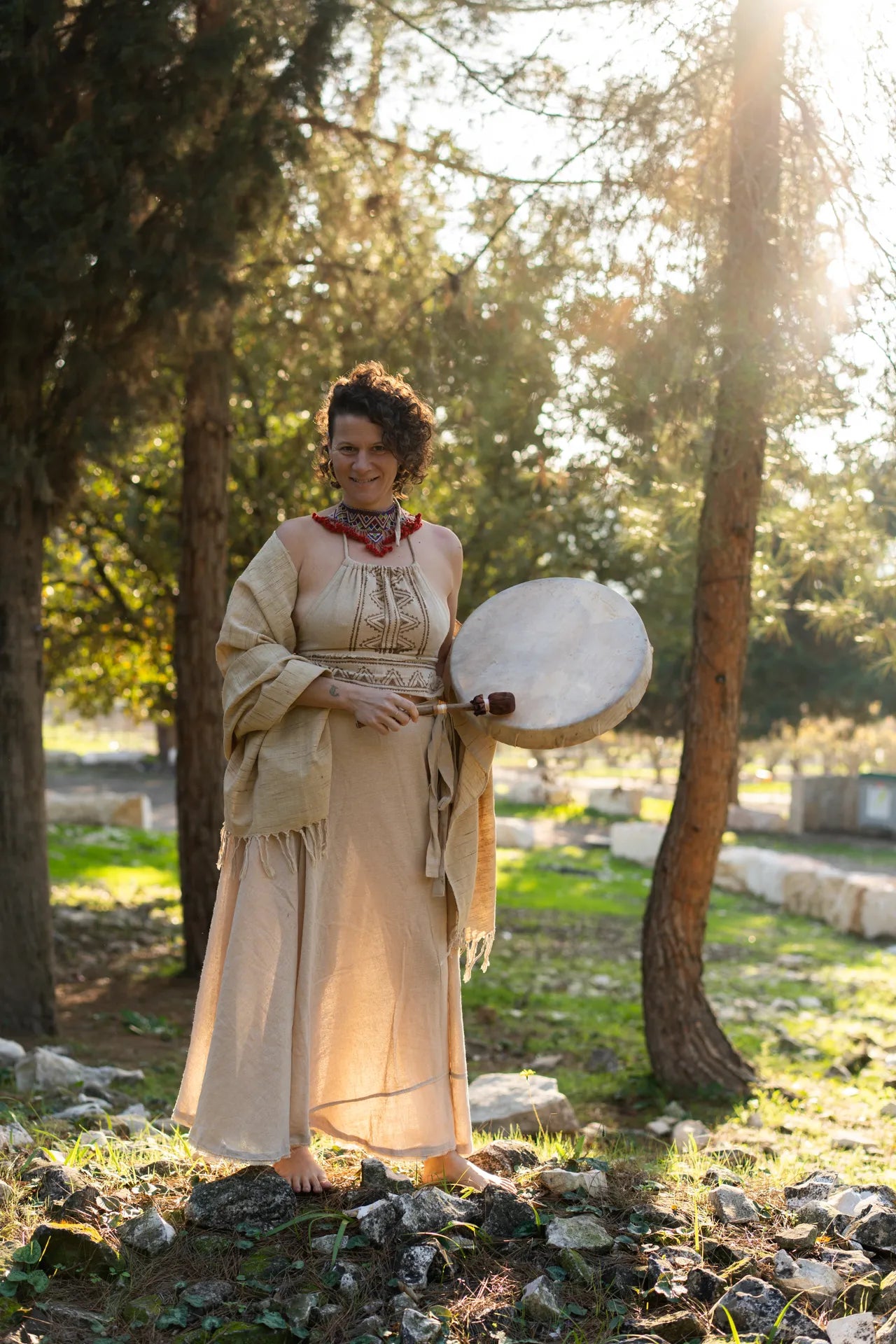 Full body view of a natural wrap skirt, halter top and shawl outfit set in a forest setting, earthy boho style.