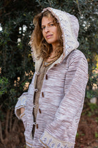 Close-up of original tribal embroidery on the hood of a woven Khadi cotton jacket, outdoors setting.