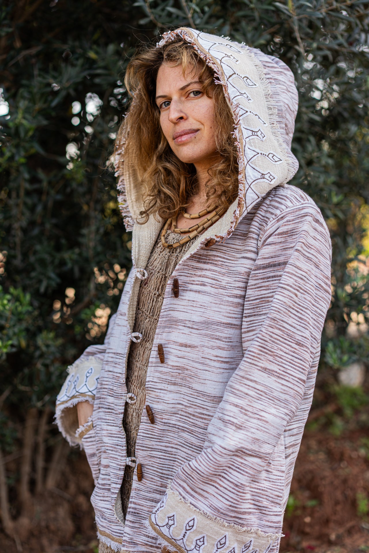 Close-up of original tribal embroidery on the hood of a woven Khadi cotton jacket, outdoors setting.
