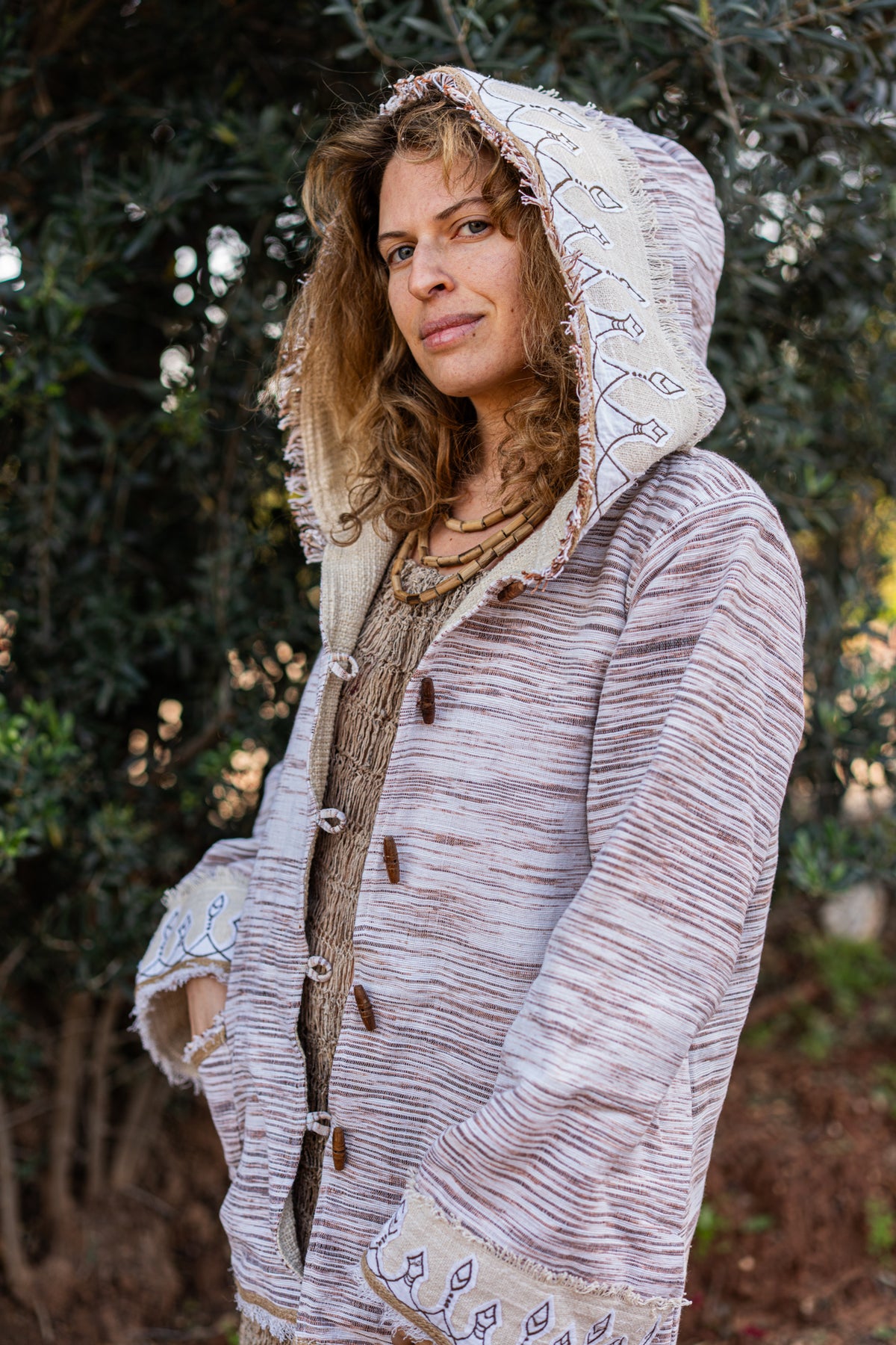 Close-up of original tribal embroidery on the hood of a woven Khadi cotton jacket, outdoors setting.