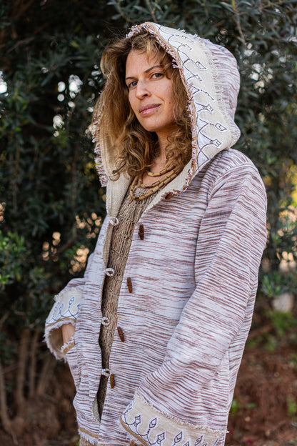 Close-up of original tribal embroidery on the hood of a woven Khadi cotton jacket, outdoors setting.