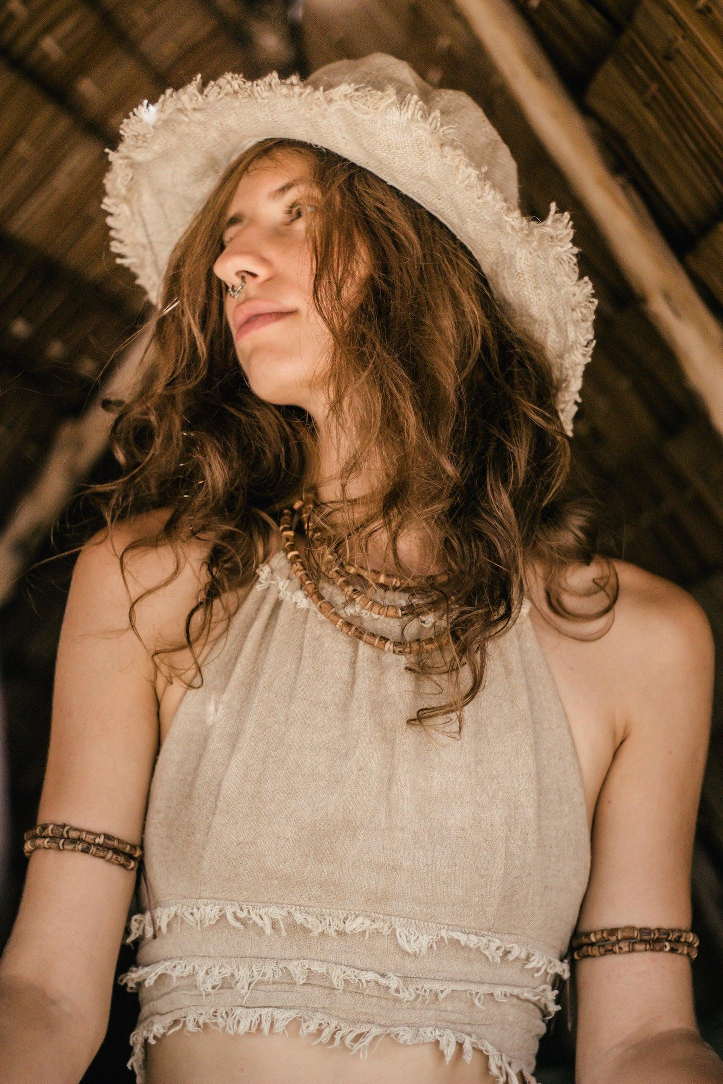 Close-up side view of the handwoven wild hemp hat showing the textured weave and frayed brim.