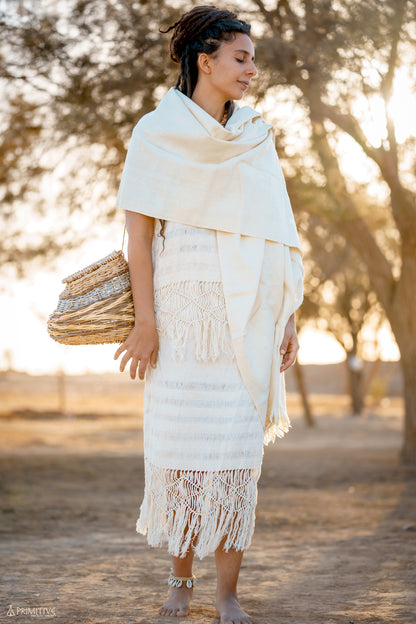 Cream handwoven natural wool shawl worn as a wrap with fringe detail, outdoor lifestyle photo