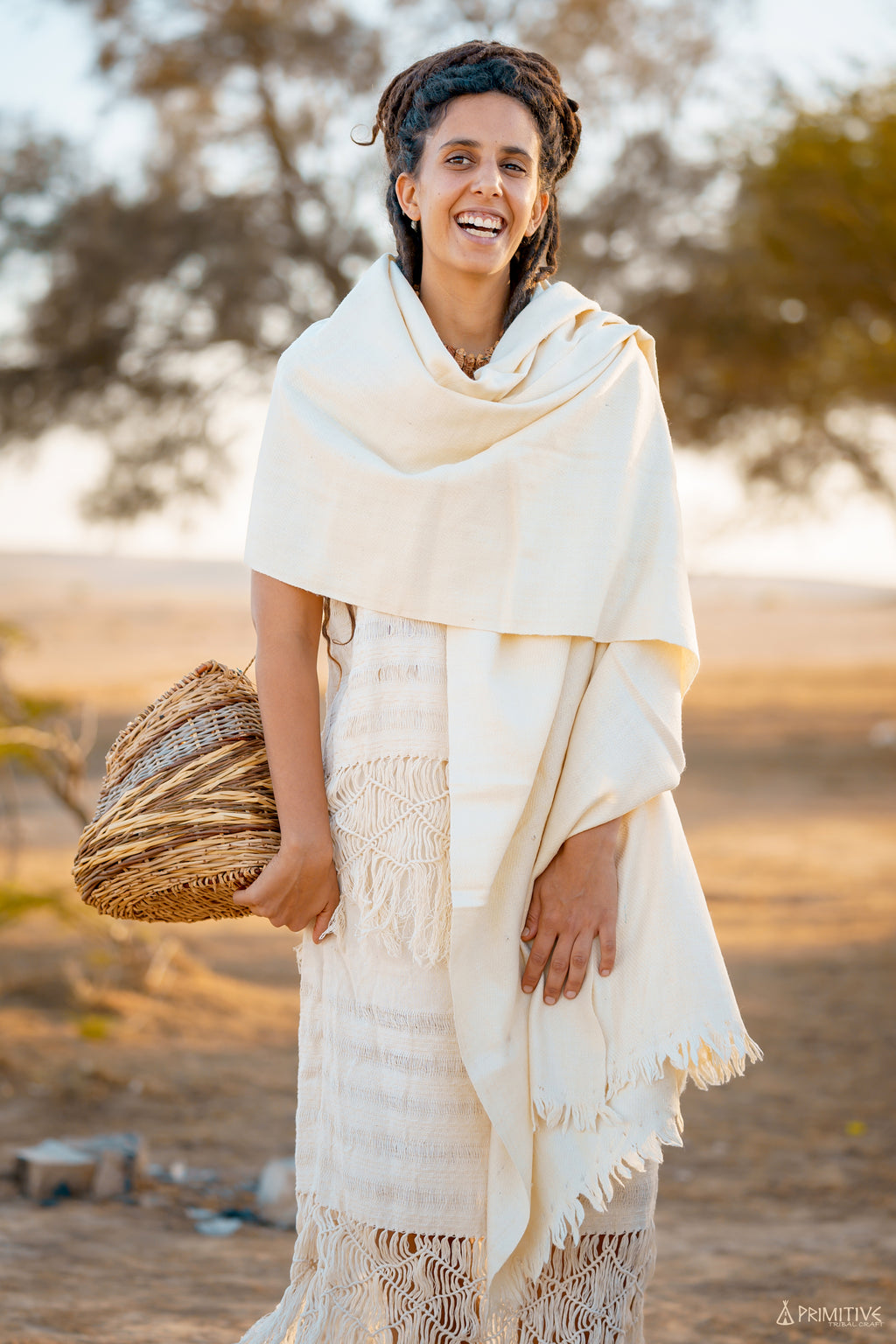Cream handwoven natural wool shawl styled as a warm wrap on a model outdoors