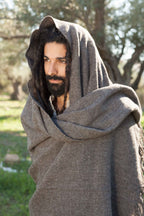 Gray handwoven natural wool shawl worn as a hooded wrap outdoors
