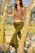 Model wearing olive green organic cotton bell bottom yoga leggings with wide flare, full length front view